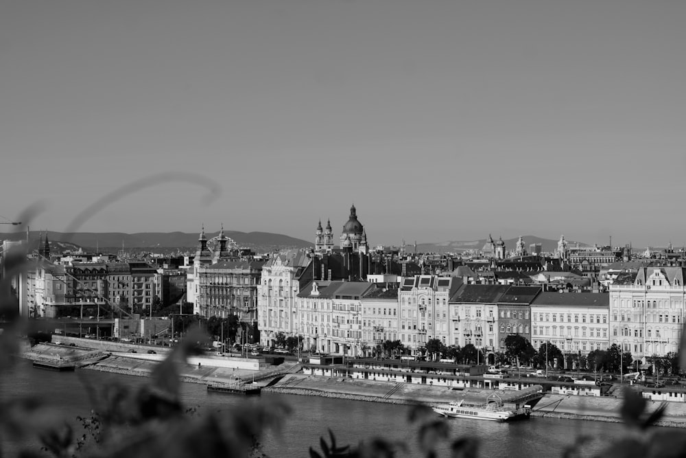 grayscale photo of city buildings near body of water