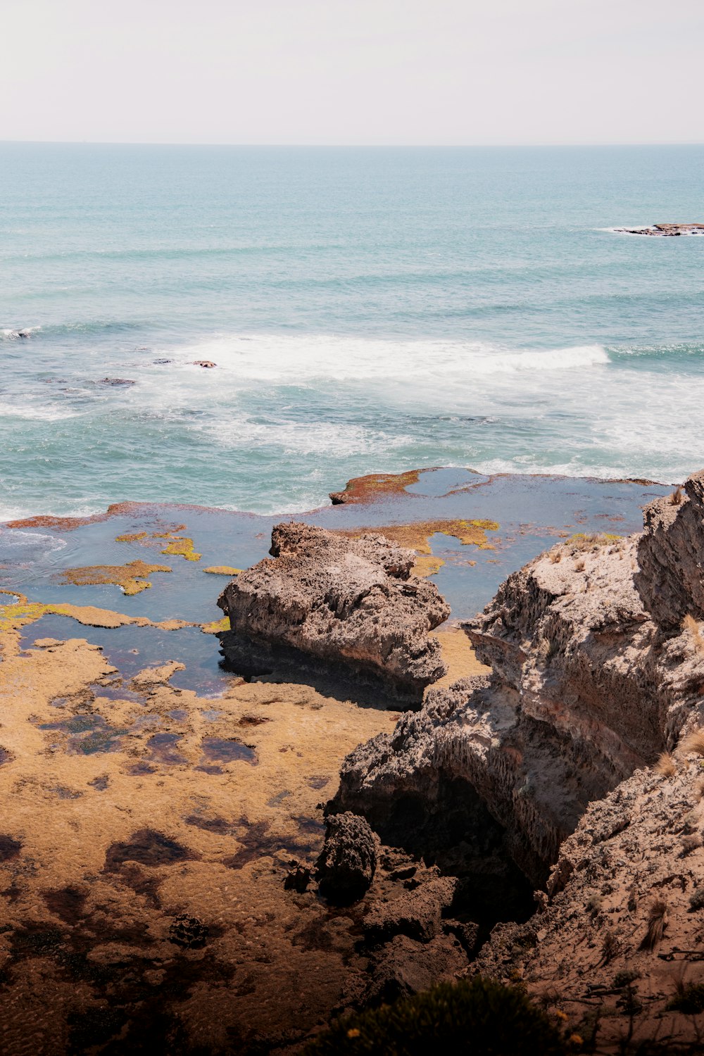 brown rocky shore with blue sea water during daytime