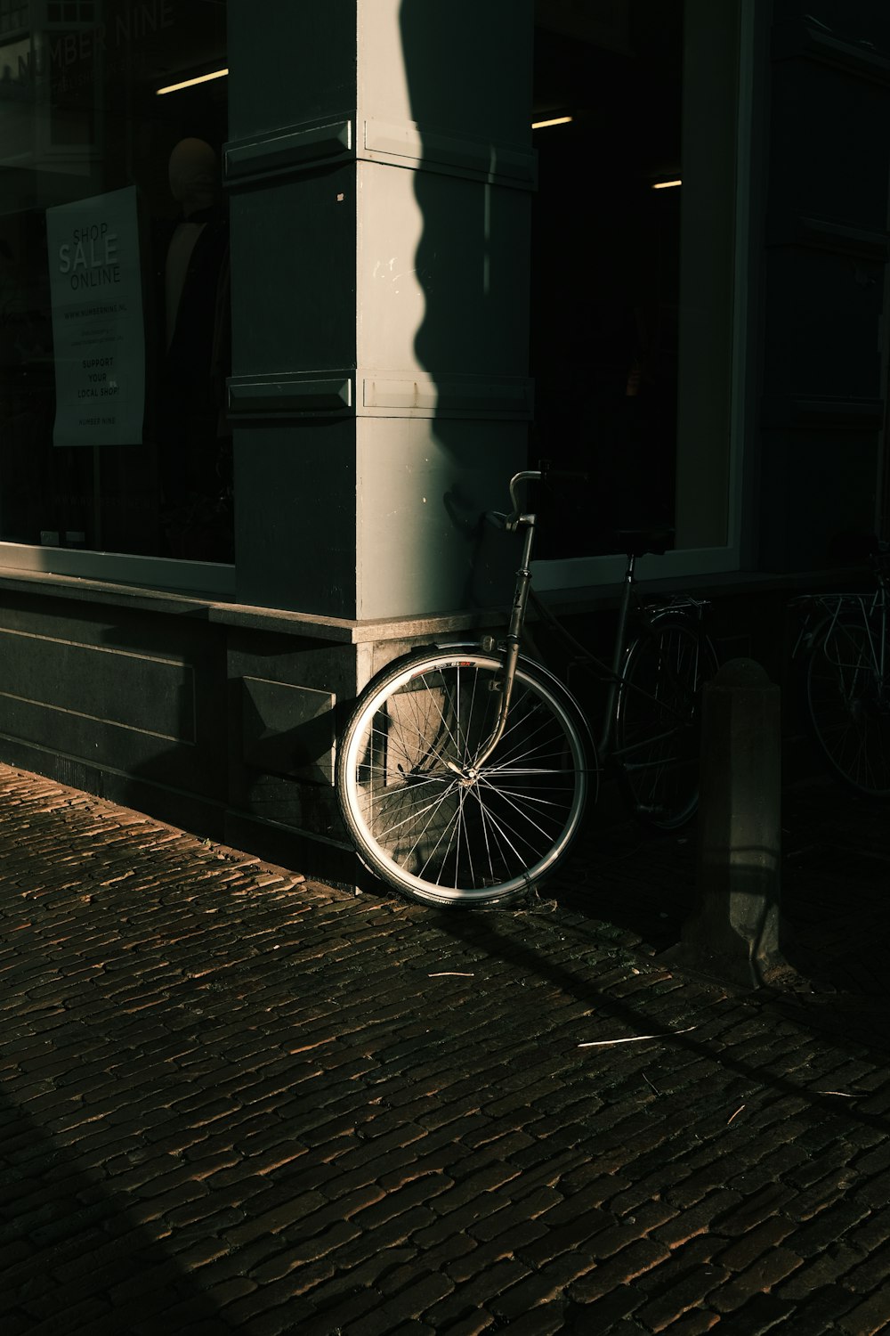 white bicycle parked beside brown brick wall