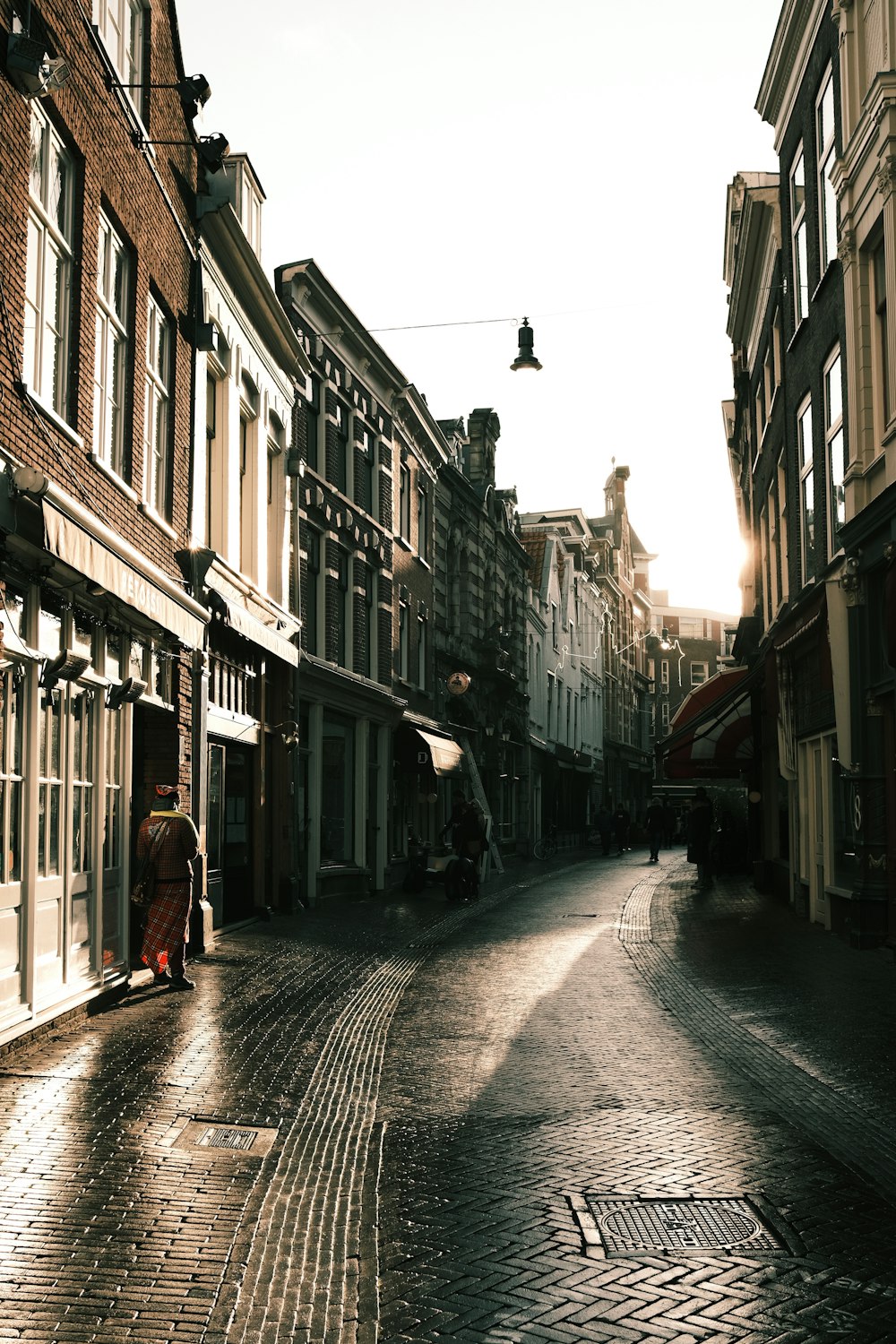 woman in red coat walking on street during daytime