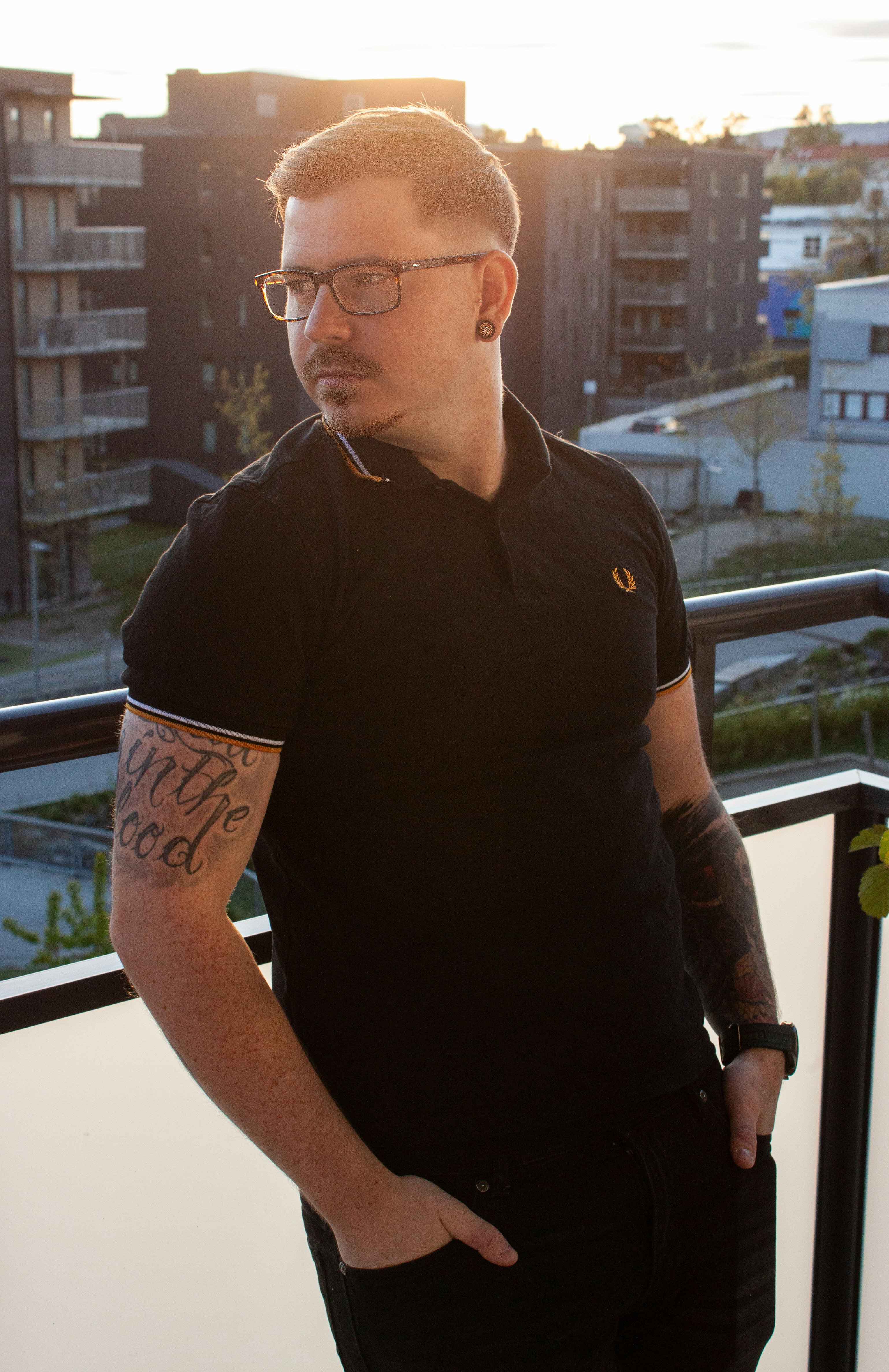 man in black polo shirt wearing black framed eyeglasses