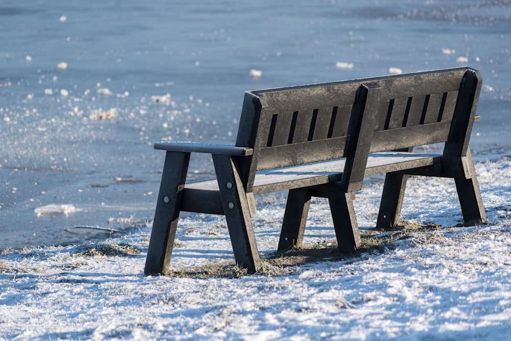 brown wooden bench on snow covered ground during daytime