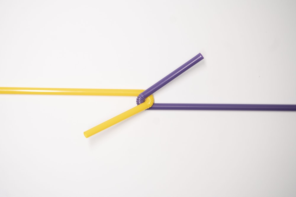 purple and yellow pencil on white background