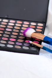 A vibrant makeup palette with brushes, showcasing a variety of colors.