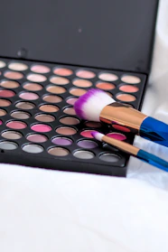 Vibrant makeup palettes and brushes displayed on a vanity table.