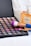 A variety of colorful eyeshadows in a palette accompanied by makeup brushes with purple bristles. A bottle of Chanel No. 5 perfume stands nearby, creating a luxurious and elegant atmosphere.