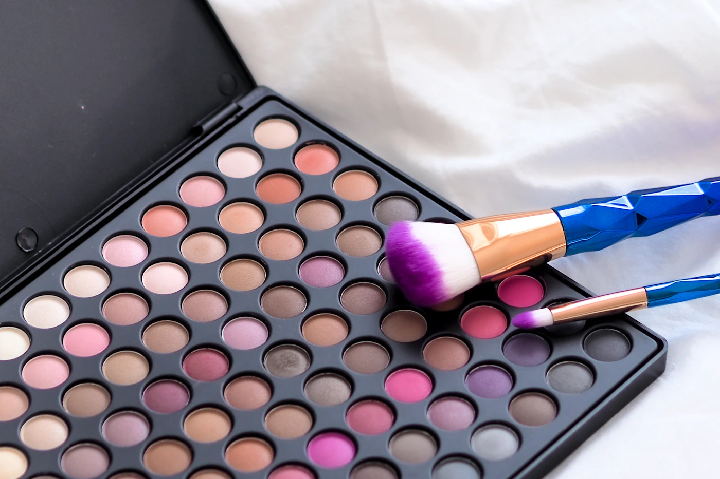 Complexion and color cosmetics arranged with beauty tools
