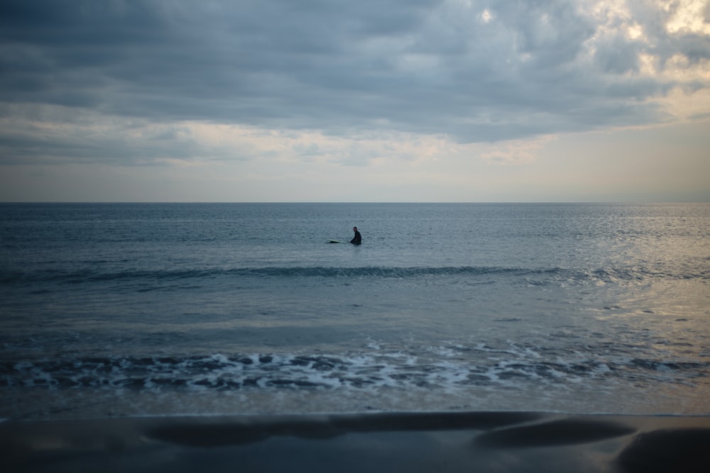 person surfing on sea waves during daytime