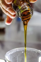 person pouring avocado oil into a mixing beaker when creating blend number 30