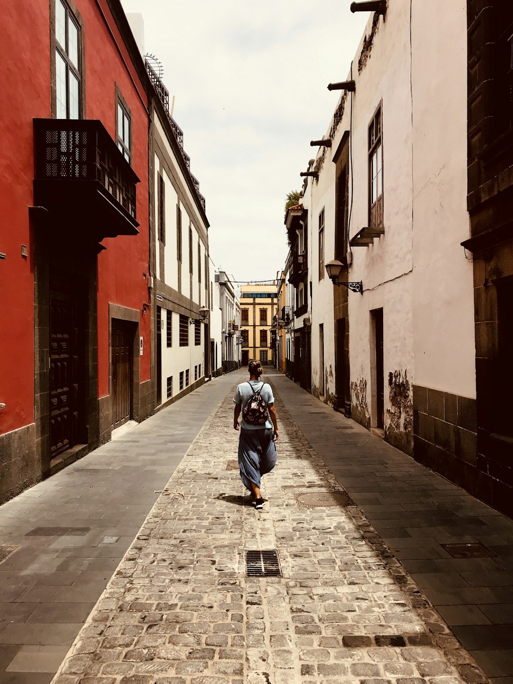 man in blue jacket and blue denim jeans riding on black motorcycle on gray concrete road