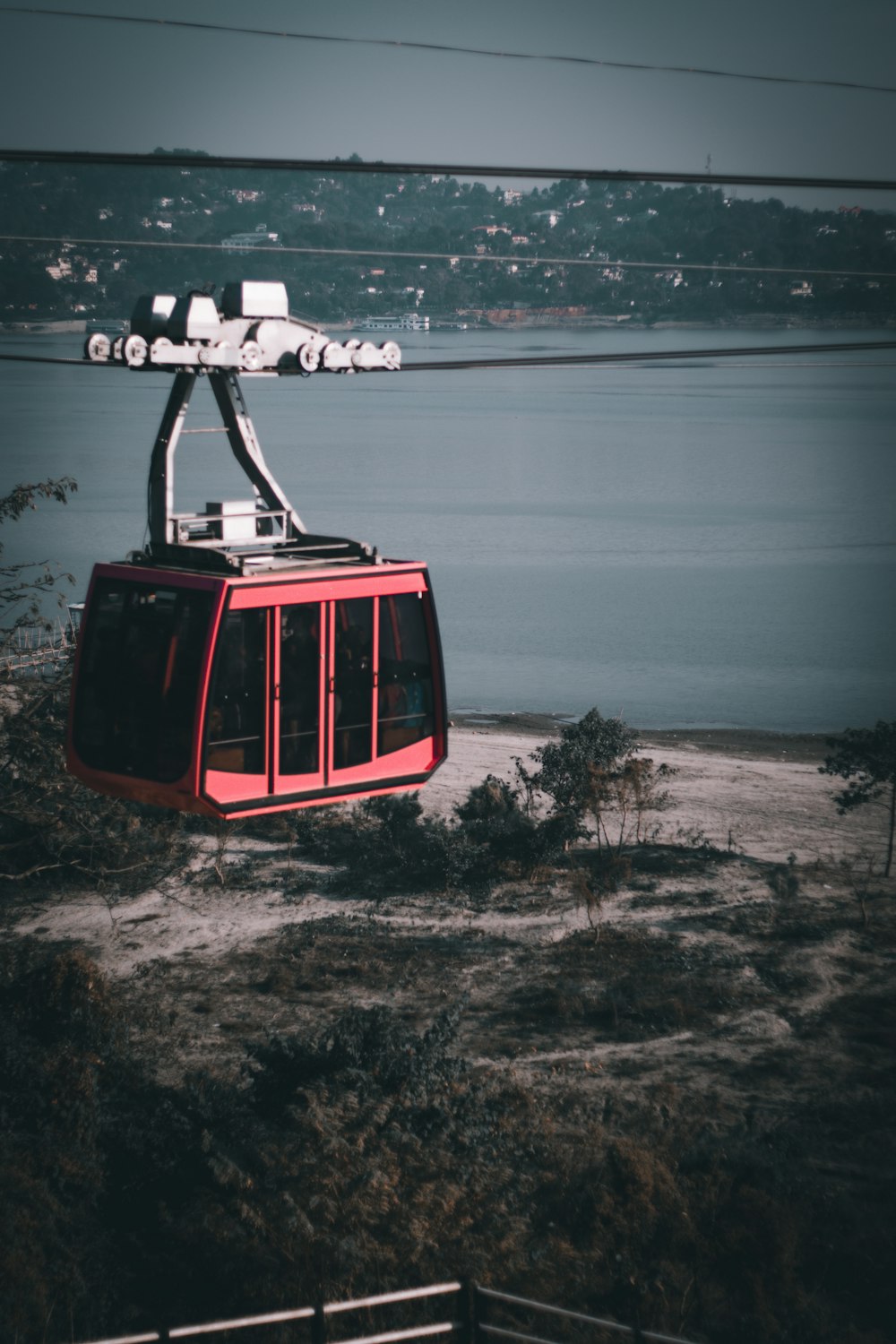 Teleférico rojo y negro sobre el mar durante el día