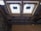 The image depicts the interior ceiling of a building under construction. There are wooden beams and a partial view of the roof structure. Two rectangular window installations are visible.