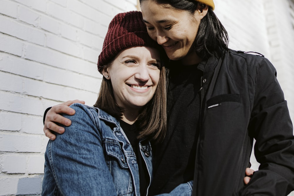 man in black jacket beside woman in blue denim jacket