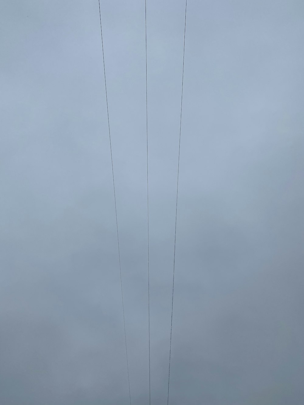 black coated wire under gray clouds