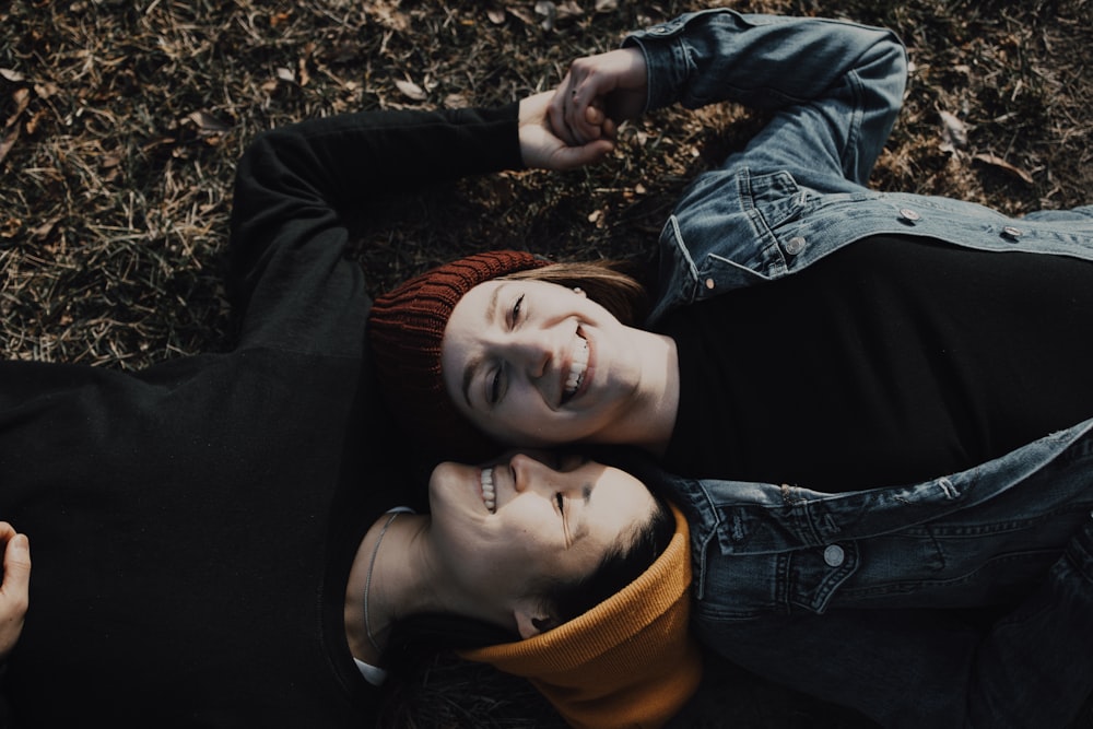 woman in black and orange long sleeve shirt lying on ground