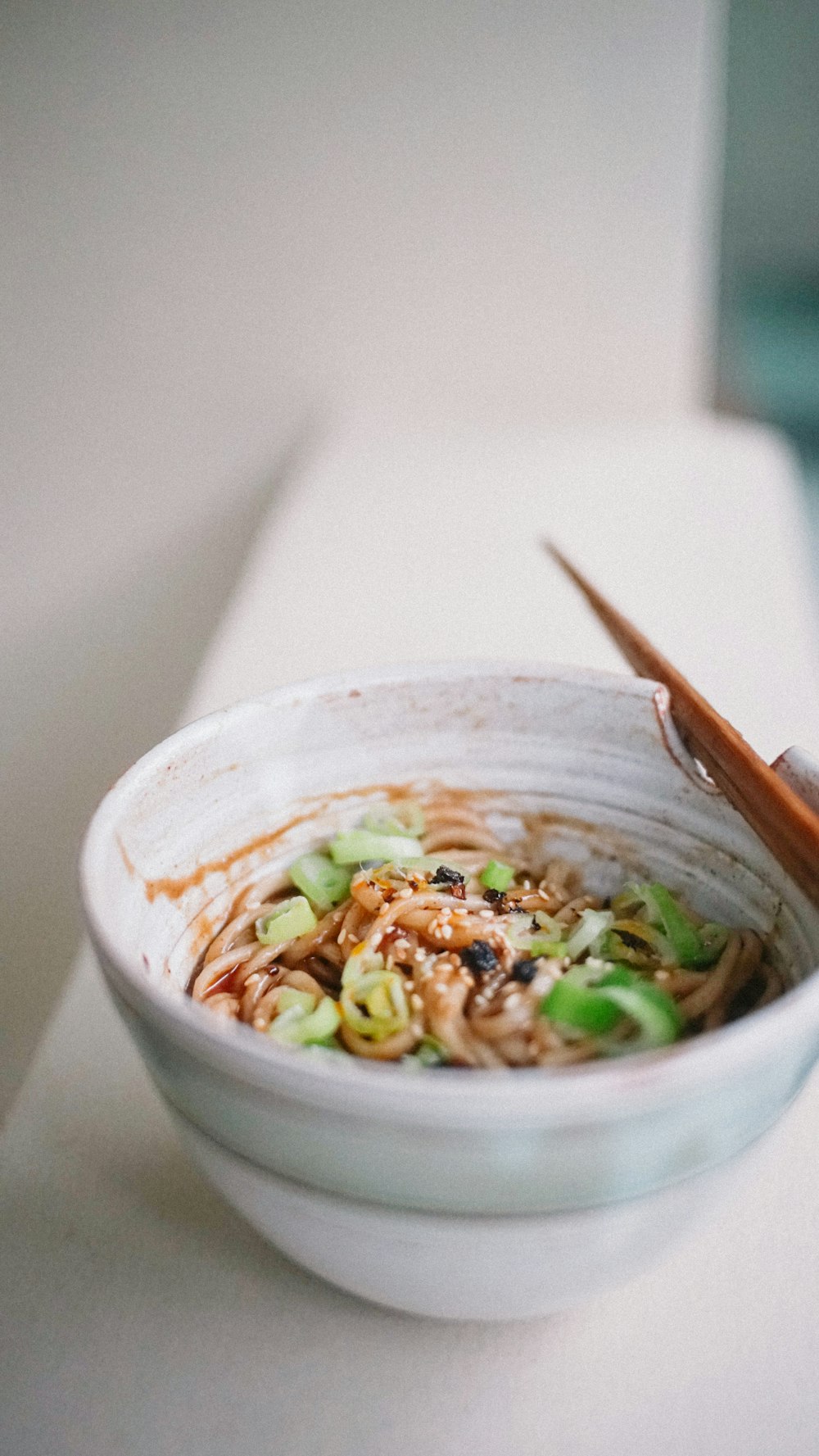 white ceramic bowl with brown chopsticks