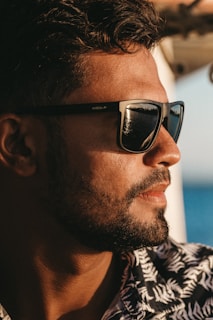 Side profile of a man wearing Dual Clear sunglasses outdoors with sunlight casting subtle shadows on his face