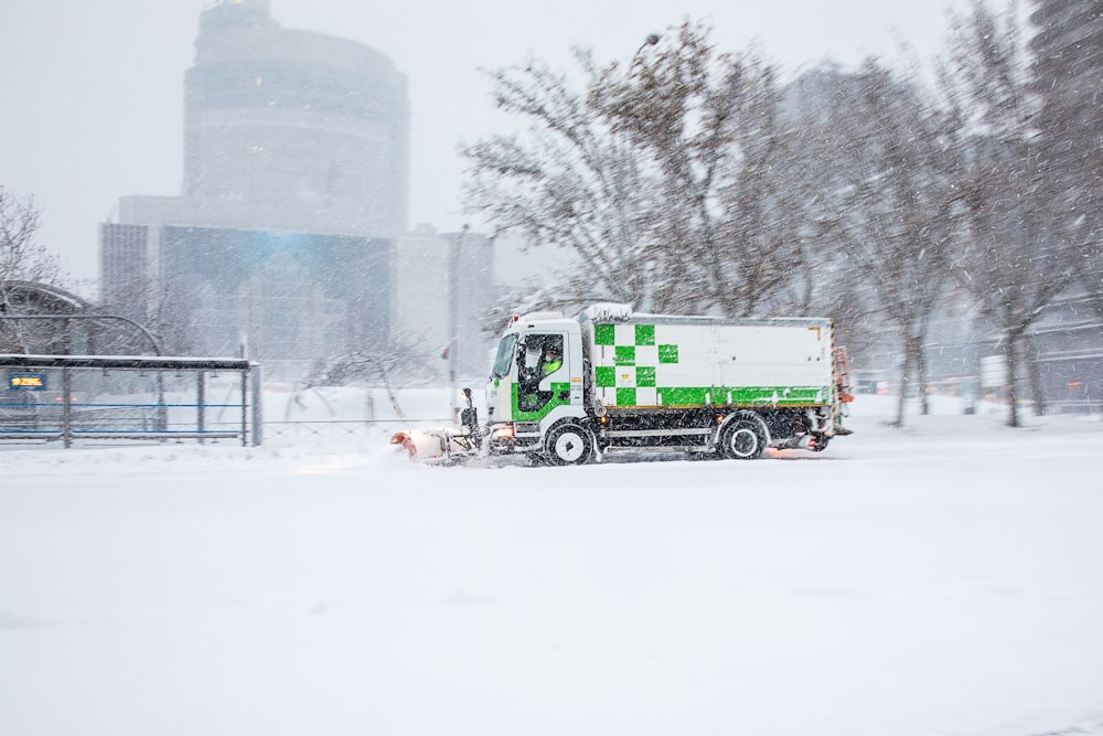 green truck on snow covered ground during daytime