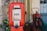 An old red tire inflator machine with a vintage design. The device has a square window displaying the number '05' and various instructions underneath. It is surrounded by a blurred background featuring some additional equipment.