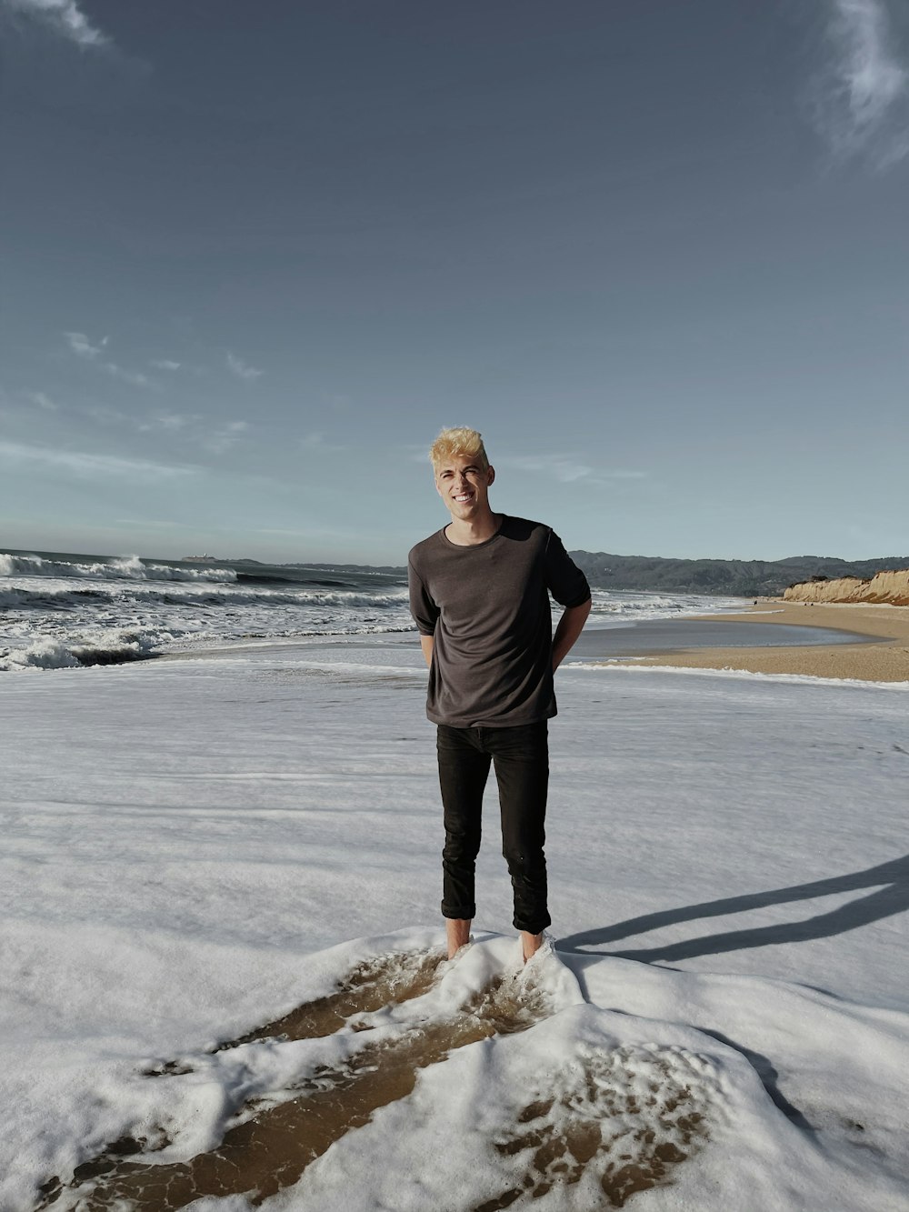 man in black long sleeve shirt standing on white snow field during daytime