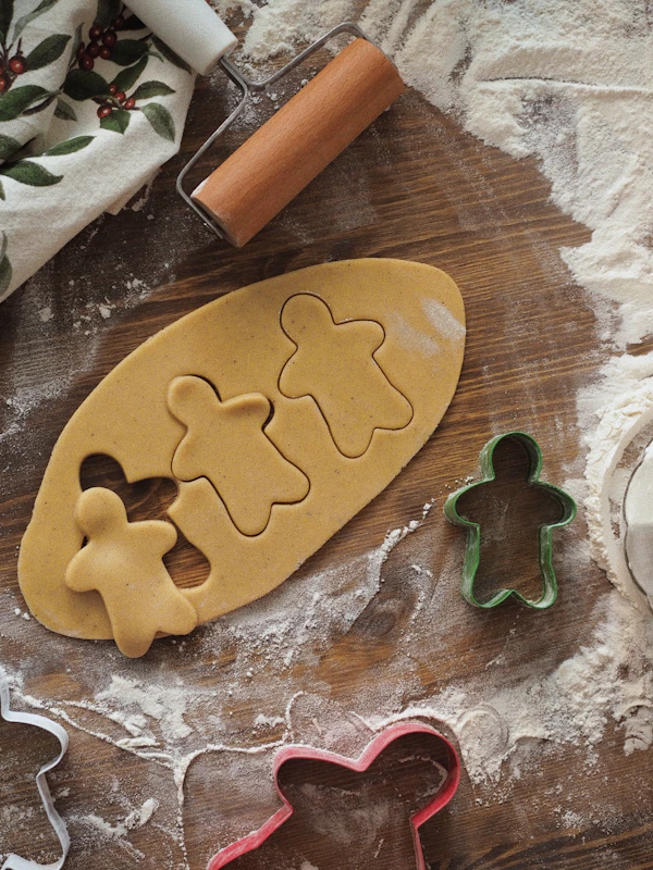 Freshly baked cookies cut into festive shapes on a baking tray