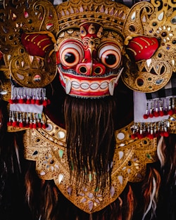red and gold mask with red and gold colored wings