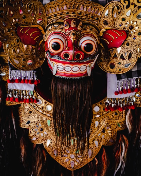 red and gold mask with red and gold colored wings