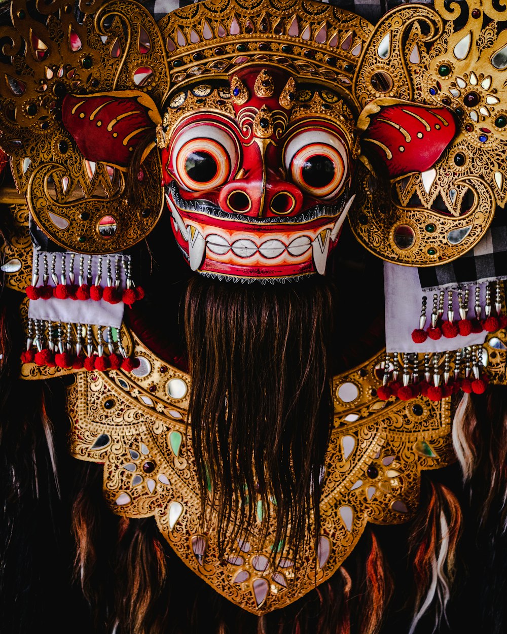 red and gold mask with red and gold colored wings