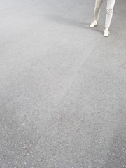 A pair of simple, clean-cut sweatpants laid out on a light fabric background.