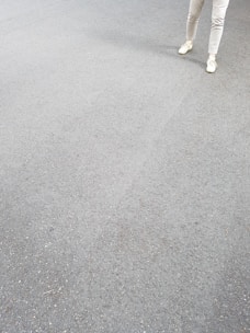 A pair of simple, clean-cut sweatpants laid out on a light fabric background.