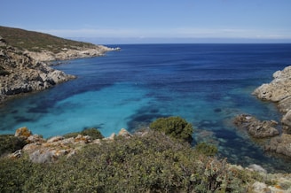 A panoramic view of a turquoise bay surrounded by rocky cliffs.