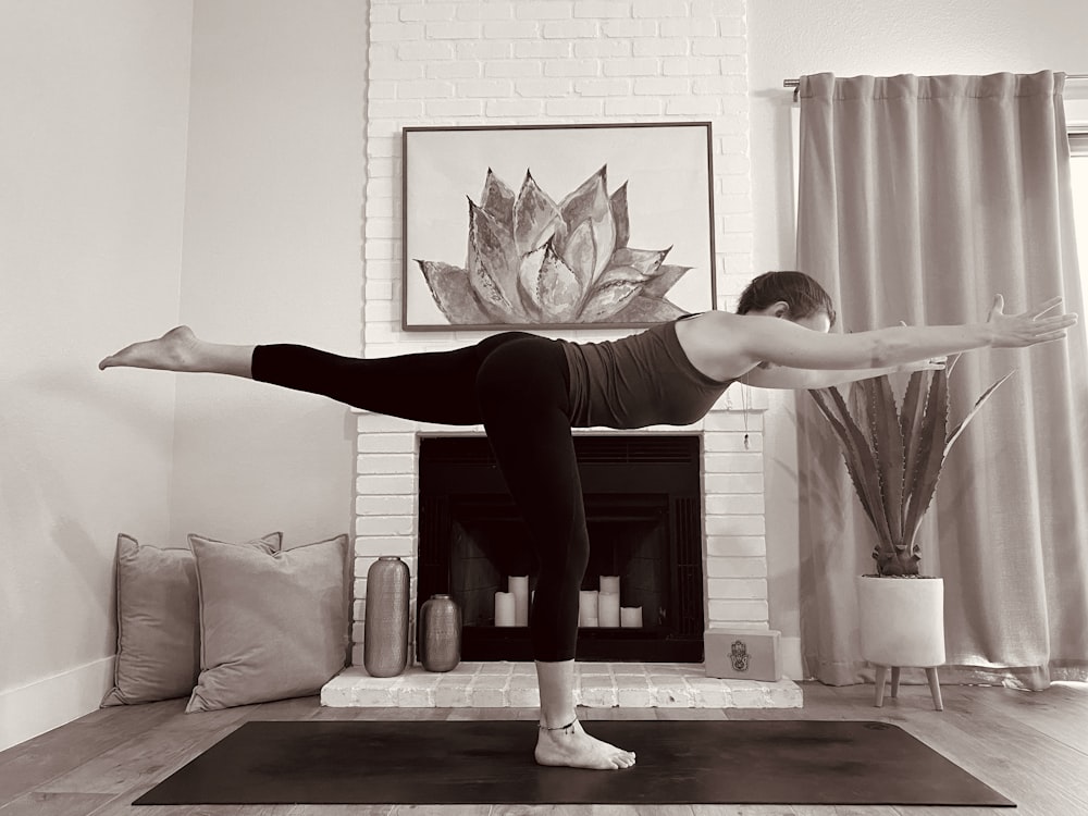 woman in red tank top and black leggings doing yoga