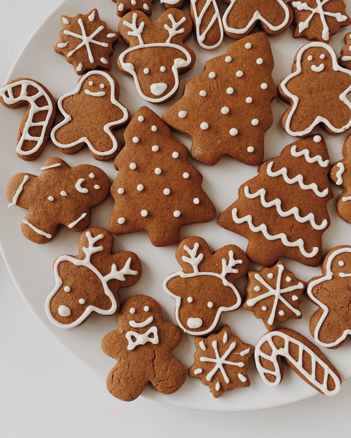 Round cookie cutters arranged on a floured surface alongside freshly cut cookie dough