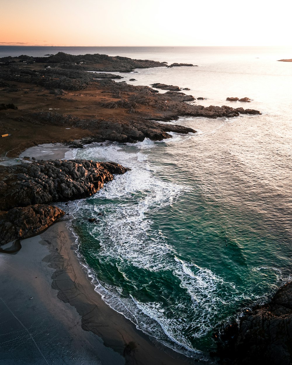 Vista aérea de las olas del mar rompiendo en la costa durante el día