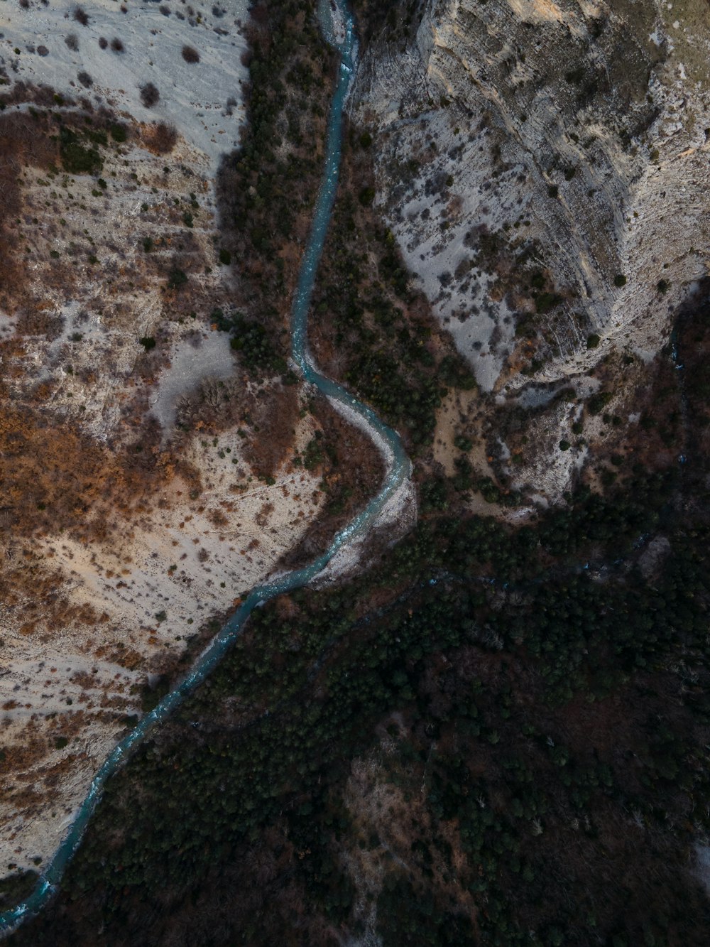aerial view of road in the middle of brown rocky mountain