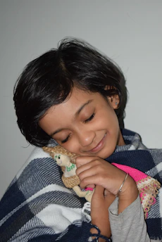 A child hugging a custom-made plush toy with a joyful smile.