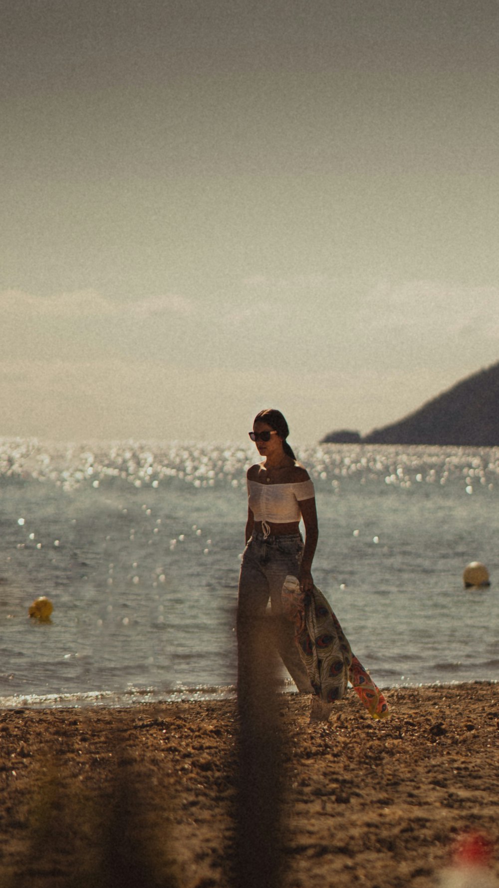 woman in black and white floral dress standing on beach during daytime