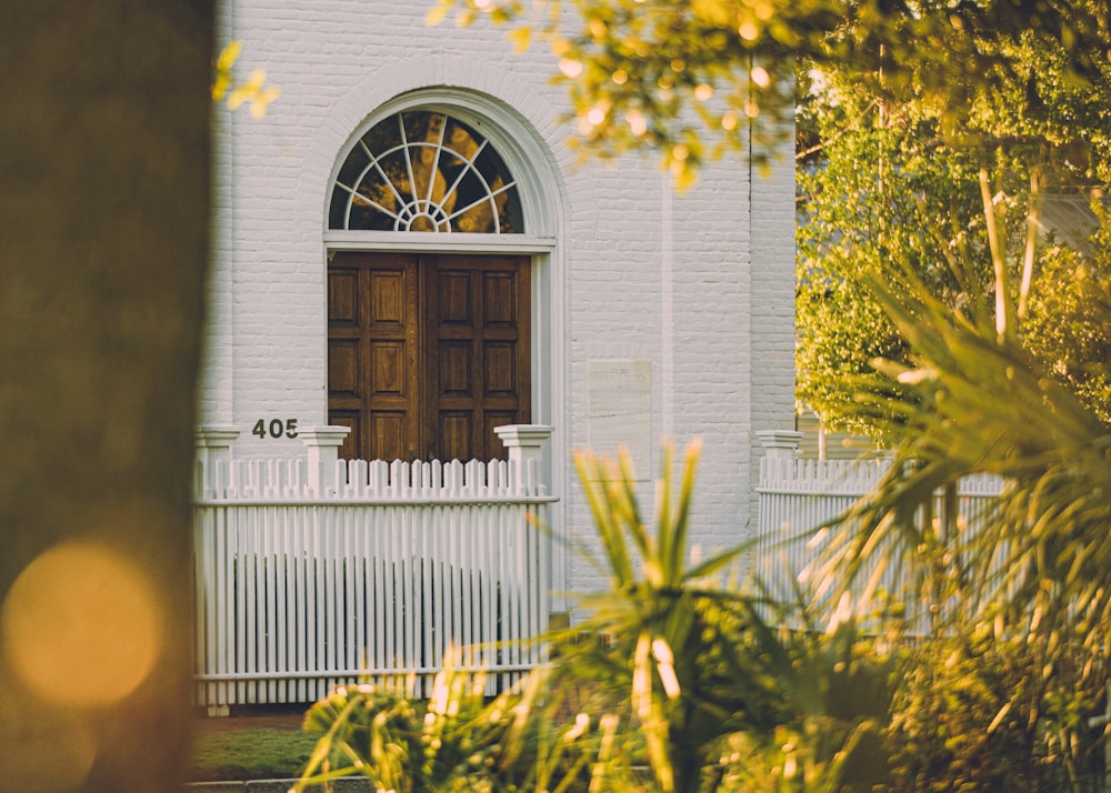 white wooden house with green plants