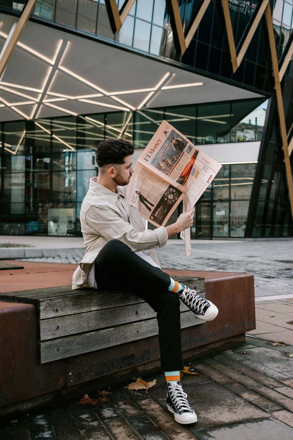 man in gray hoodie reading newspaper