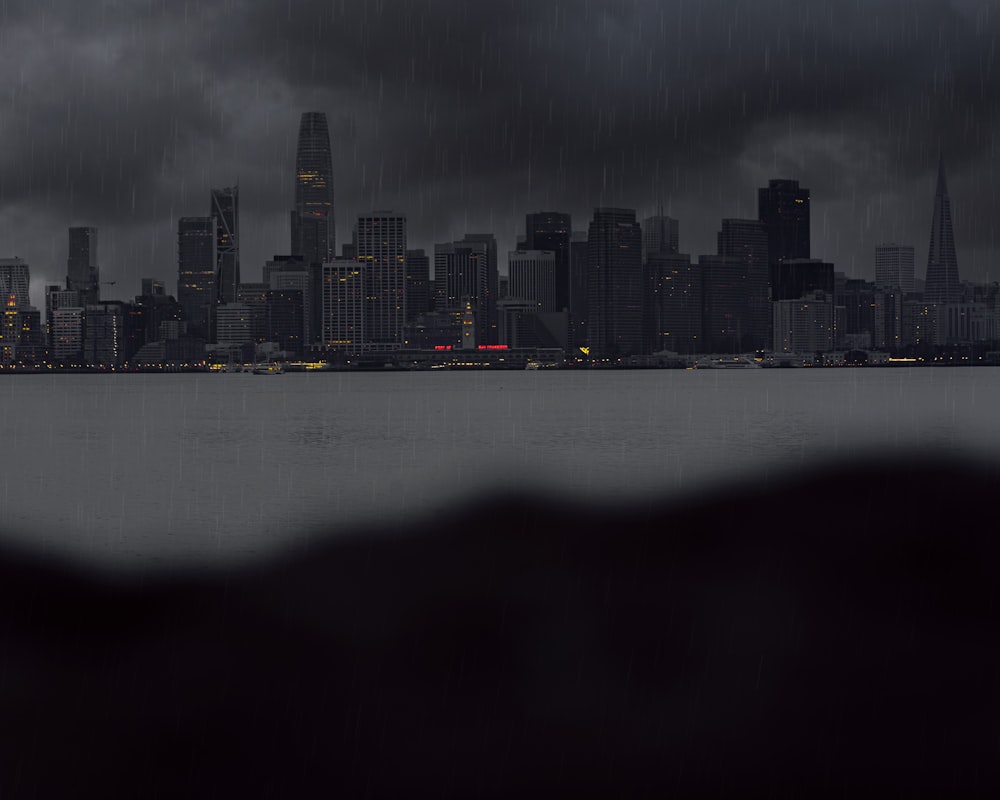 city skyline across body of water during night time