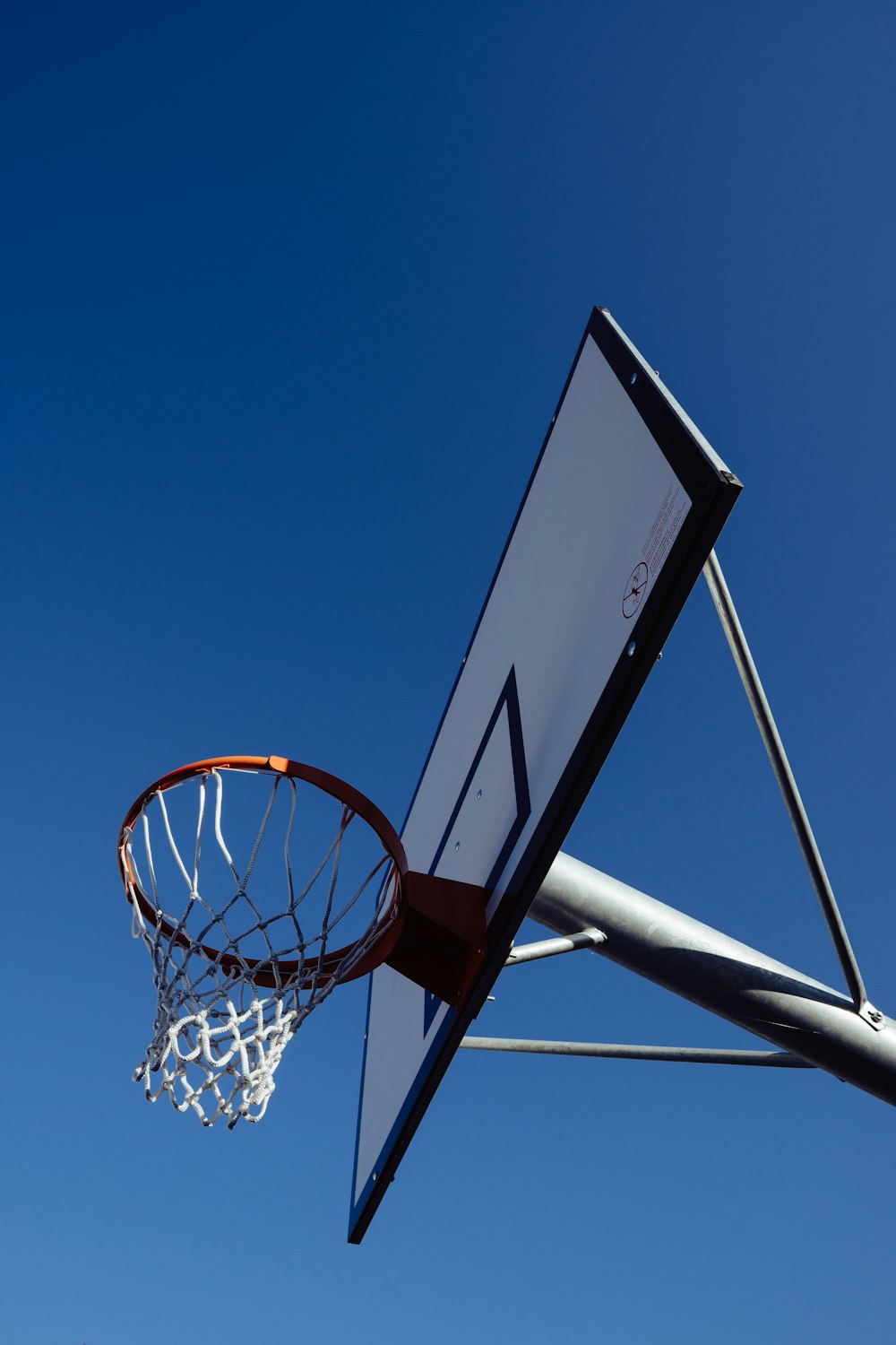 white and black basketball hoop under blue sky during daytime