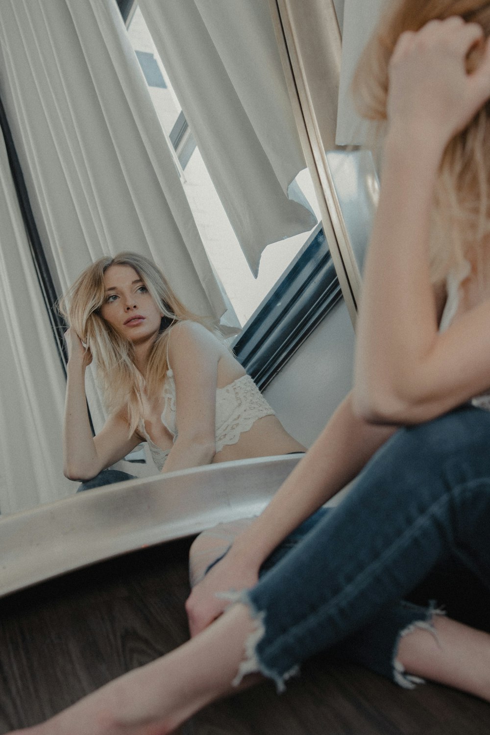 woman in blue denim jeans sitting on window