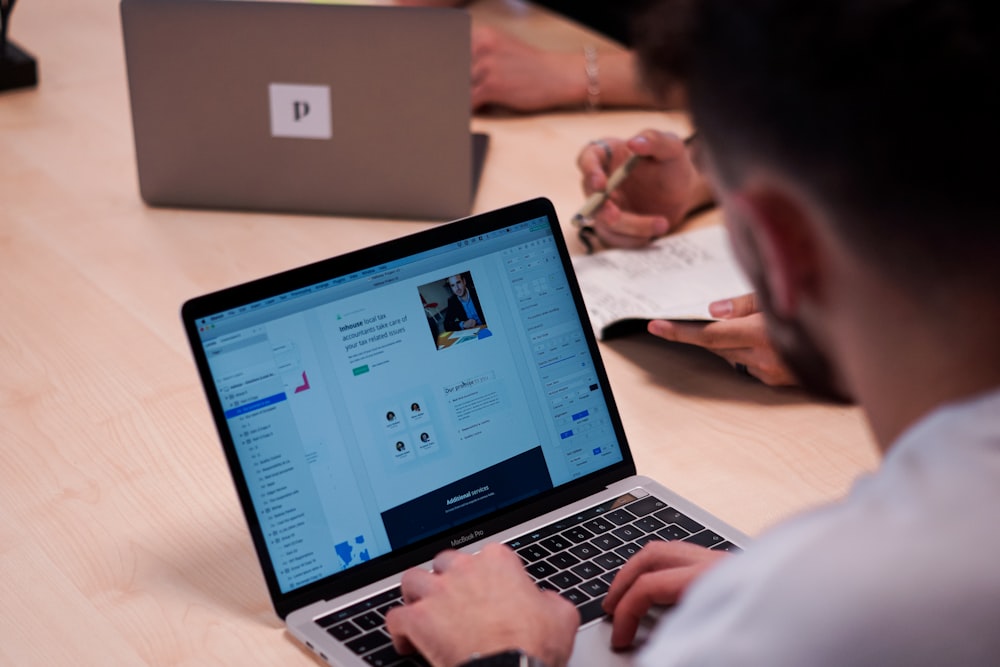 person using macbook pro on table