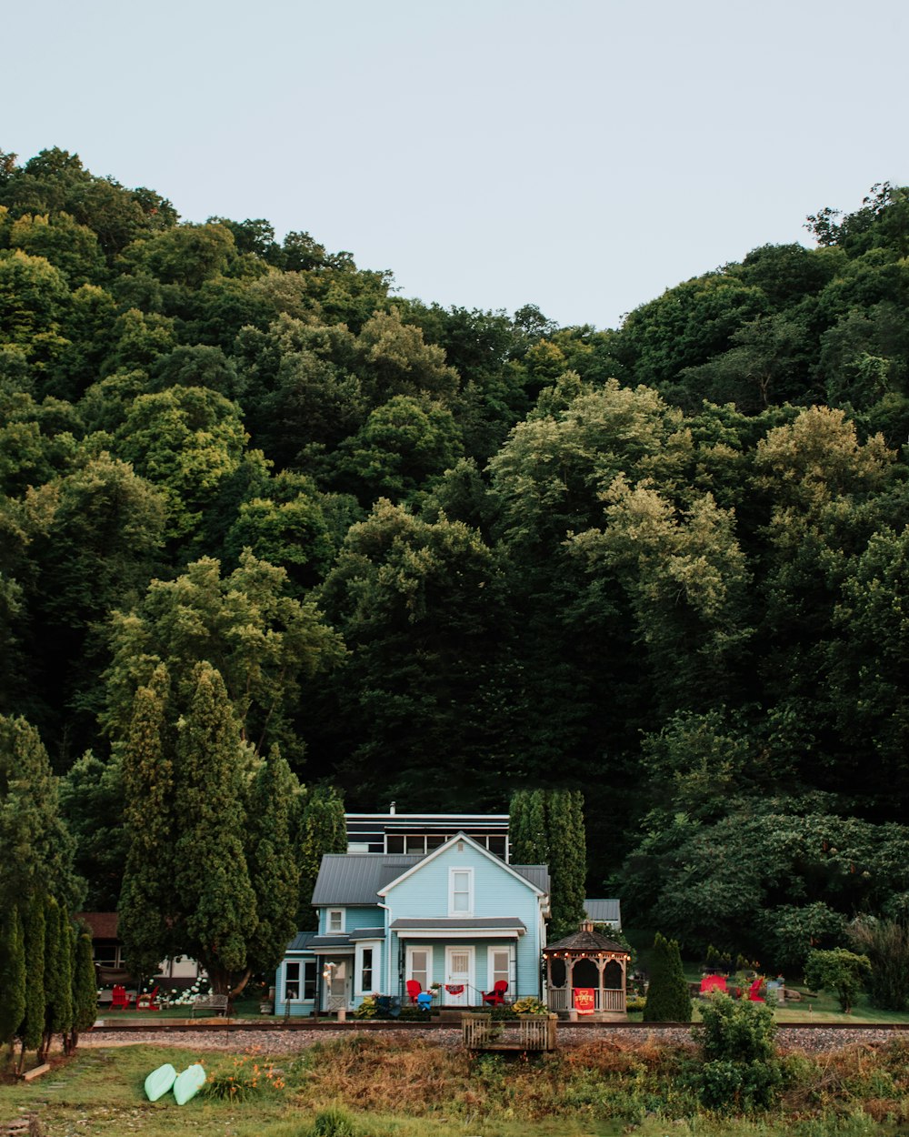 alberi verdi vicino alla casa bianca e blu durante il giorno