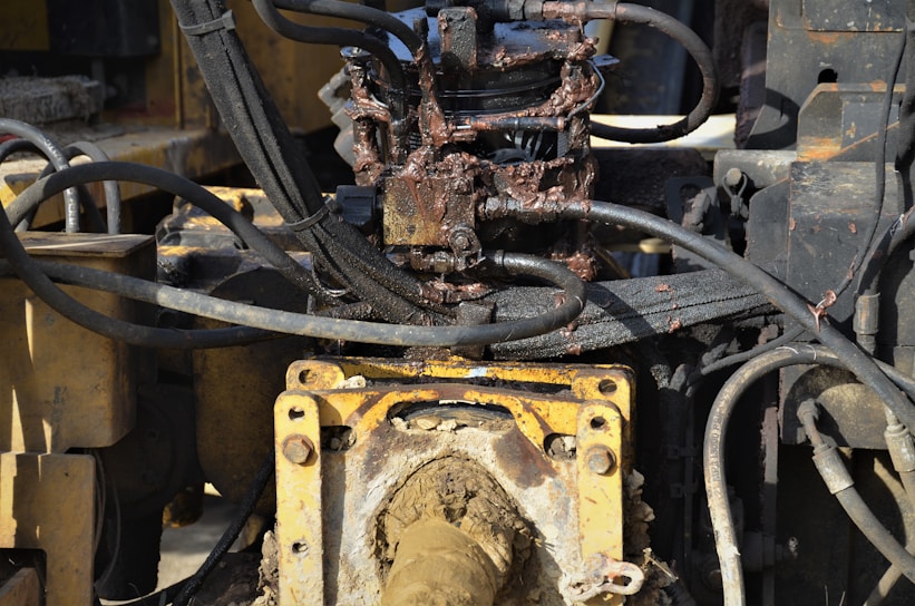 Close-up of a heavy-duty industrial machine being lubricated with grease.