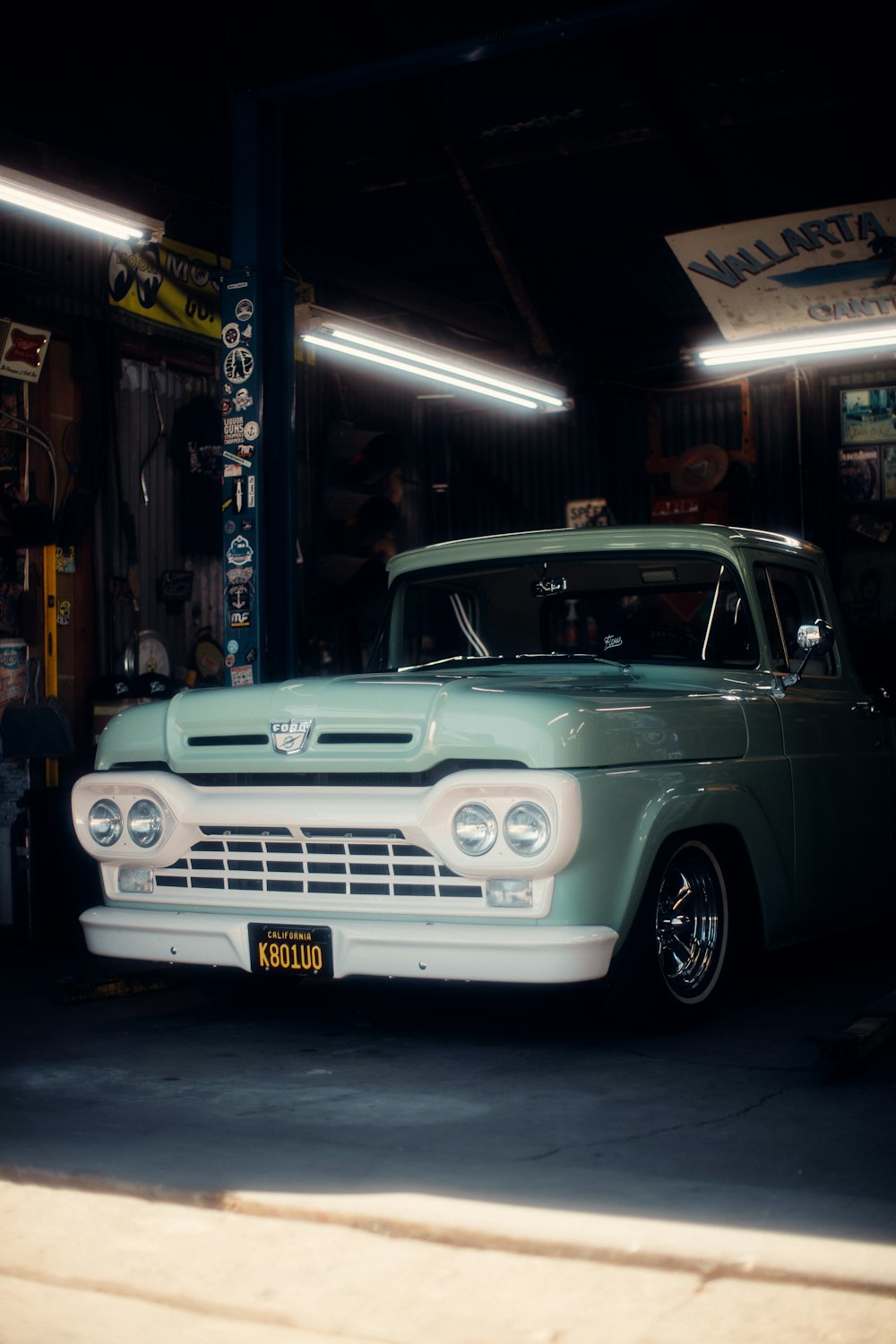 teal classic car parked near store