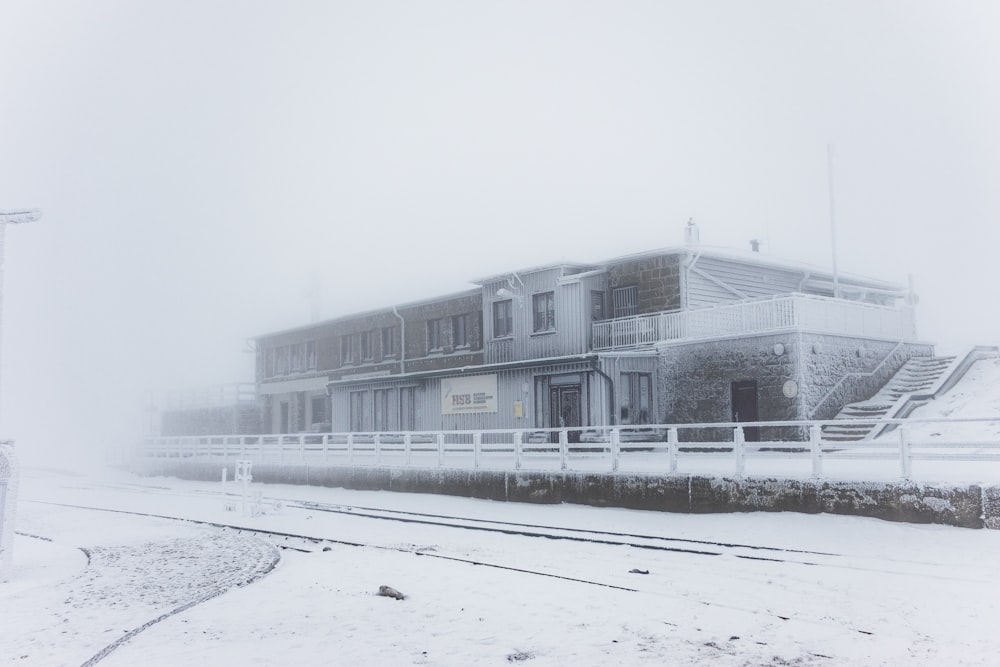 edificio in cemento bianco vicino al campo innevato durante il giorno