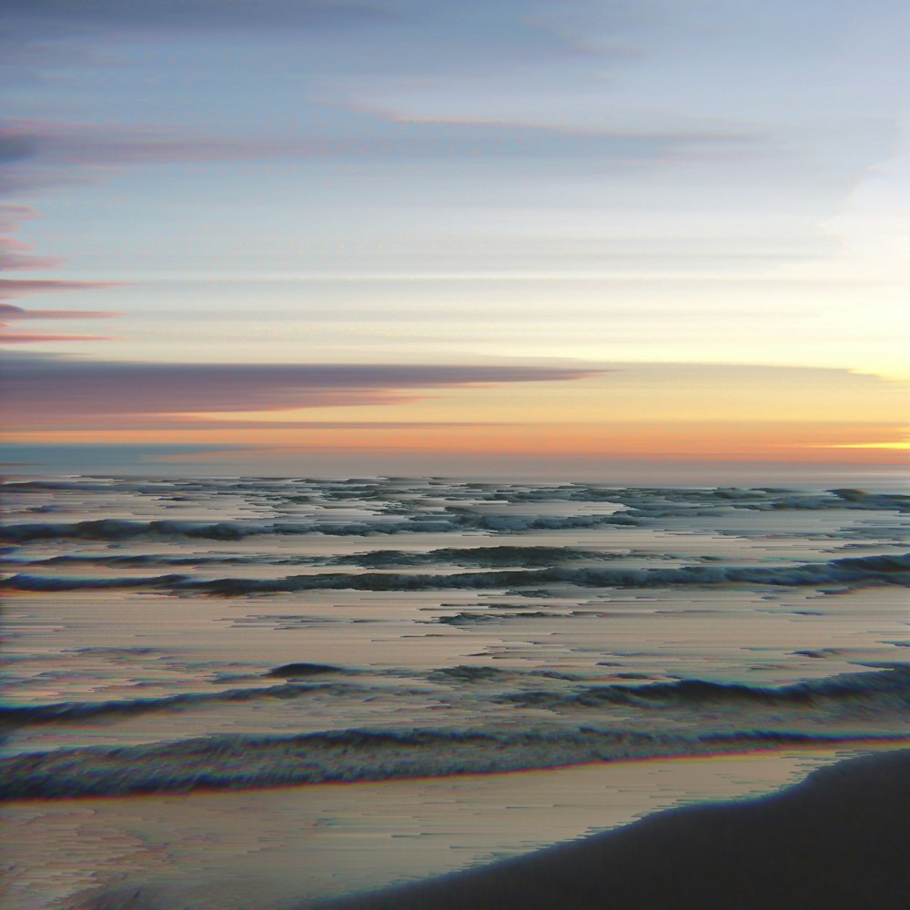 sea waves crashing on shore during sunset