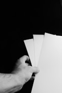 Hands holding family data forms over a table.