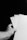 A hand holding three white sheets of paper against a dark background. The paper sheets are fanned out, and the scene is captured in black and white.